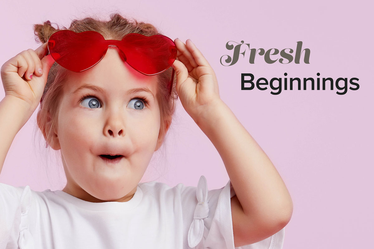 A pigtailed little girl raises her red heart-shaped glasses and mouths "oooooh!" as she reads the title "Fresh Beginnings."